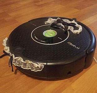 An iRobot with lace and black bows as if a cap and collar, like a maid would wear on her uniform.