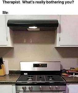 Therapist asks, "What's really bothering you?" I reply with a photo, in a kitchen, of a stove. Above it is a range hood, mounted several inches to the left of the range itself.