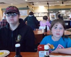 14YO Leelan and almost-9YO Lyra looking serious at the table.