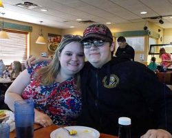 Casey with her boy Leelan, smiling - he is so much taller than she is!