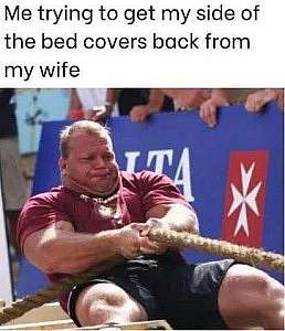 Photo of a large heavily muscled man exerting maximum strain against a thick rope. Caption: My trying to get my side of the bed covers back from my wife.