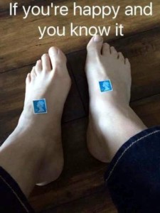 photo of bare feet with postage stamps stuck to the top of them. Caption: If you're happy and you know it