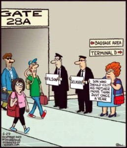 people disembarking from a plane. 3 people are standing at the exit holding signs: two men in suits and chauffeur caps holding signs with a name on them; the 3rd is a middle-aged woman holding a sign saying, "Son who should visit his mother more than just once a year."