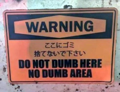 An orange sign. WARNING at the top. some kanji below that. English at the bottom says, "Do not dumb here. No dumb area."
