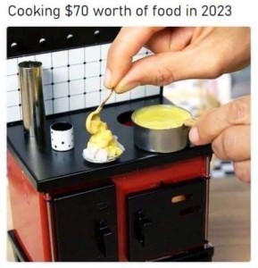 A pair or hands is preparing food on a teeny-tiny, dollhouse-sized stove, spooning some gravy from a tiny saucepan onto a tiny plate of mashed potatoes with a tiny spoon. Caption: Cooking $70 worth of food in 2023