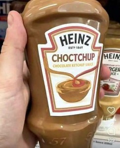 A hand holding a bottle of Heinz Choctchup (chocolate ketchup sauce)