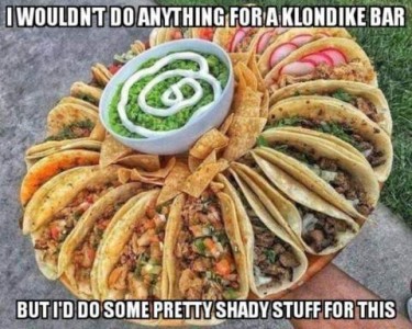 A platter with a variety of beautiful tacos, with some nacho chips around a bowl of guacamole topped with sour cream in the middle. Caption: I wouldn't do anything for a Klondike bar, but I'd do some pretty shady stuff for this.