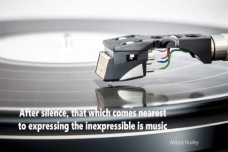 Black and white close-up photo of a needle arm on a record. Quote: After silence, that which comes nearest to expressing the inexpressible is music. Aldous Huxley