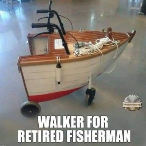 A photo of the front of a boat, complete with a buoy and ropes. It has had wheels attached to the bottom, and handles with brakes at the top near the rear, with a cutout behind them in the middle. Caption: Walker for retired fisherman