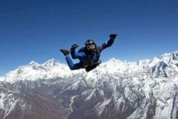 a person that appears to be hanging in midair, above the mountain tops