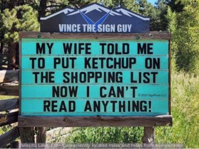 A sign by Vince The Sign Guy says, "My wife told me to put ketchup on the shopping list, now I can't read anything!"