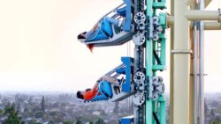 A close up of people on roller coaster cars, being pulled vertically upward.