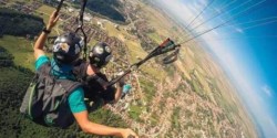 two people far above the earth with parachutes.