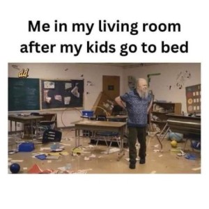 A man standing, hands on hips, in a room with stuff all over floor, in total chaos. Caption: Me in my living room after my kids go to bed.
