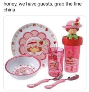 Text: "Honey, we have guests, grab the fine china" Photo of a set of plastic Strawberry Shortcake dishes.