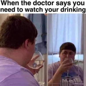 A woman is standing in front of a mirror holding a wine glass (I think?) and watching herself drink from it. Caption: When the doctor says you need to watch your drinking.