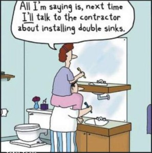 Cartoon of a man brushing his teeth at the bathroom sink; his wife is also brushing hers, sitting on his shoulders, at her bathroom sink several feet above his. She is saying, "All I'm saying is, next time *I'll* talk to the contractor about installing double sinks!"