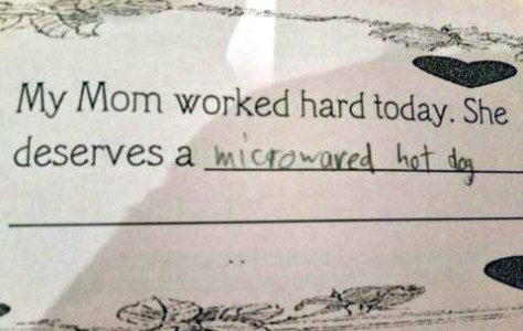Photo of a portion of a school assignment, saying, "My mom worked hard today. She deserves a..." with the words in a child's hand, "microwaved hot dog"
