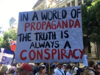 Placard held up by someone in a crowd: "In a world of propaganda the truth is always a conspiracy."