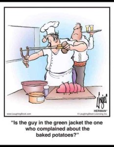 Cartoon with a chef holding a slingshot loaded with a potato aimed out toward the dining room as a waiter looks on. Chef is saying, "Is the guy in the green jacket the one who complained about the baked potatoes?"