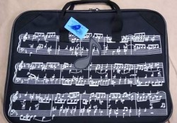 A flat black bag with short handles, with a music manuscript printed in white on the side. There is still a price tag hanging from one of the handles.