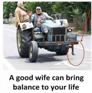 Photo of an older quite hefty farmer driving a tractor that's at least as old as he is; to his right his hefty wife stands on the rear corner of the tractor. A red circle is drawn to show that there is no left front tire at all. Text: A good wife can bring balance to your life.