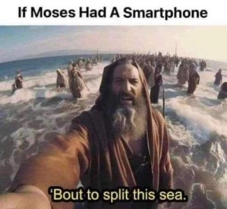 A photo of a bearded old man in robes, standing at the edge of the ocean with many people in the same style behind him; his right arm is holding a phone that is taking a selfie. Text: If Moses had a smartphone - "'Bout to split this sea..."