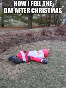 Photo of a partially-deflated Santa yard decoration laying on his back on the ground. Caption: How I feel the day after Christmas