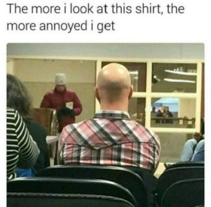 Photo of the back of a man taken by someone behind him, as they are sitting in some sort of lecture. Caption: The more I look at this shirt, the more annoyed I get. Photo shows the back of the man's bald head and his plaid shirt with the seam between the top and bottom of it off-center.