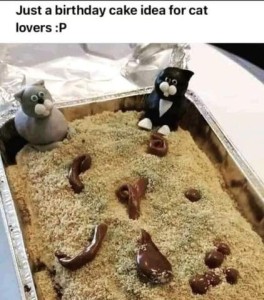 Photo of a cake in a baking pan, topped with crumbles, and little splats and shapes of chocolate frosting randomly placed on top. There are 2 plastic cats sitting in the corners. Caption: Just a birthday cake idea for cat lovers.