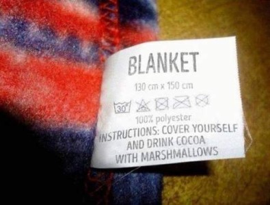 Closeup photo of a tag on a blanket. It reads: BLANKET 130cm x 150cm. 100% polyester. INSTRUCTIONS: cover yourself and drink cocoa with marshmallows.