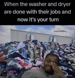 A man cleaning back in a chair, a pained look on his face, fingers over one eye. Behind him is a big building and stacks and stacks of clothes piled more than halfway up the side. Caption: When the washer and dryer are done with their jobs and now it's your turn.