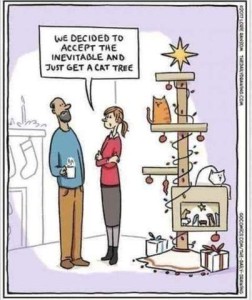 Cartoon of a woman talking to a man in her living room. Behind her is a cat tree with Christmas lights on it, a manger scene, gifts at the bottom, lights wound around, and ornaments hanging. There is a white cat and an orange cat sitting on it. The woman is telling the man, "We decided to accept the inevitable and just get a cat tree."
