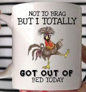 Closeup photo of a coffee cup with a dancing chicken on it and the words, "Not to brag but I totally got out of bed today."