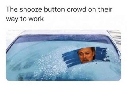 Picture of a windshield, taken from the front, totally covered in frost with only a small area directly in front of the driver's face scraped off. Caption: The snooze button crows on their way to work.