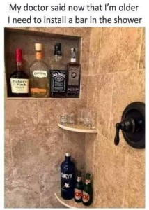 Photo taken inside of a tile shower, with bottles of booze where the shampoo bottles would be, shot and beer glasses on one corner shelf, and beer bottles on the other. Caption: My doctor said now that I'm older I need to install a bar in the shower.
