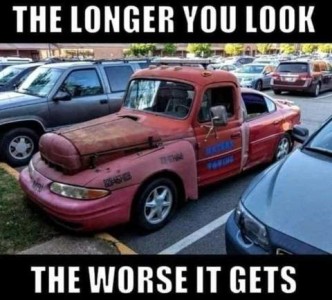 Photo of a truck that was put together with many different parts of various auto bodies; has a normal truck cab, with the front half of a car over the engine, another part of some sort covering that, and the back half of the car instead of a bed on the truck cab. It is parked in a parking lot maybe at a mall? Caption: The longer you look, the worse it gets.