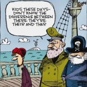 Cartoon showing a pirate and the ship's captain talking on their pirate ship at sea. A younger bearded guy is walking past them. The captian tells the pirate, "Kids these days...don't know the difference between there, they're, their, and thar."
