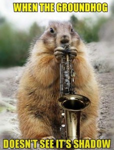 Photo of a groundhog facing the camera playing a saxophone. Caption: When the groundhog doesn't see its shadow