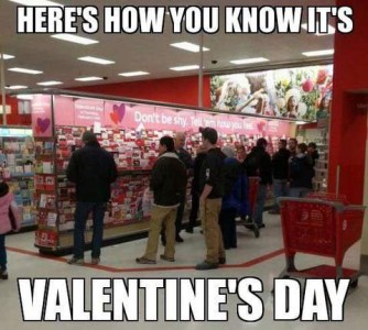 Photo of a dozen or so men looking at the Valentine's Day card display in a store. Caption: Here's how you know it's Valentine's Day.